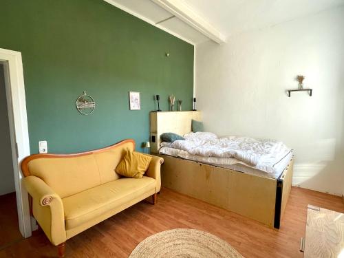 a living room with a bed and a couch at Das "Alte Jagdhaus" - mit großem Grundstück für 3 Personen in Groß Garz