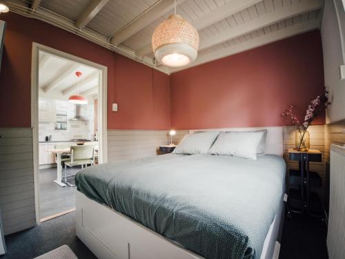 a bedroom with red walls and a large bed at Kamille | 4 persons in Gasselte