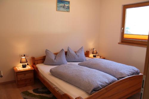 ウムハウゼンにあるHaus Sennhofのベッドルーム1室(青い枕のベッド1台、窓付)