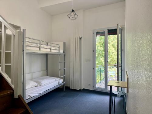 a room with two bunk beds and a window at éthic étapes Le Cart - Sommières in Sommières