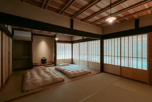 a room with a bed in a room with windows at inishie in Nishinoomote