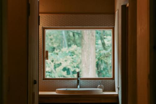 a bathroom with a sink and a window at inishie in Nishinoomote
