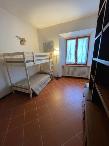a room with two bunk beds and a tile floor at Casabei in Monticiano