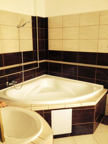a bathroom with a tub and a sink at Diófa Vendégház in Bükkszék