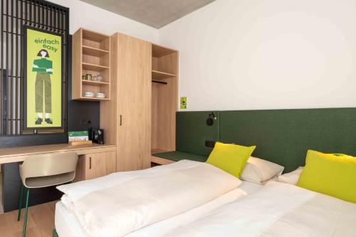 ein Schlafzimmer mit zwei Betten in Gelb und Grün in der Unterkunft eee Hotel Laakirchen in Laakirchen