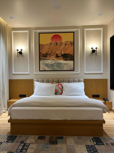 a bedroom with a large bed with three pictures on the wall at Ek Tara Guest House in Udaipur