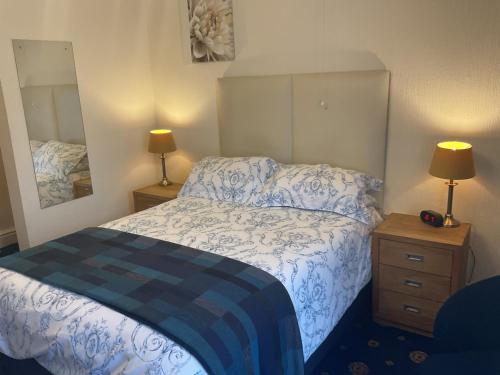 a bedroom with a bed and two lamps and a mirror at Ivy House B&B in Dolgellau