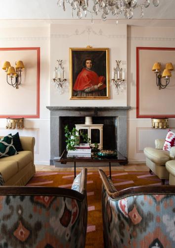 a living room with a fireplace and a painting at Palazzo Tiglio - A Small Luxury Hotels of the World in San Pancrazio
