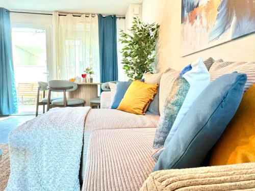 a living room with a couch with colorful pillows at Charming Tournefeuille House in Tournefeuille
