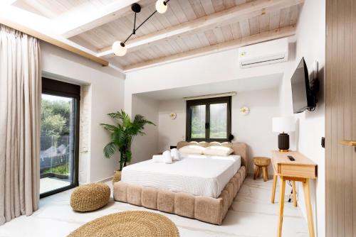 a bedroom with a large bed and a tv at The Four Villas Hanioti by Luxlikehome in Hanioti