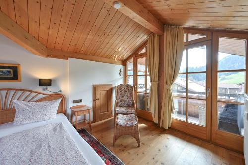 ein Schlafzimmer mit einem Bett, einem Stuhl und einem Fenster in der Unterkunft Ferienwohnung Edelweiß mit Sommer- Bergbahn unlimited kostenlos in Obermaiselstein