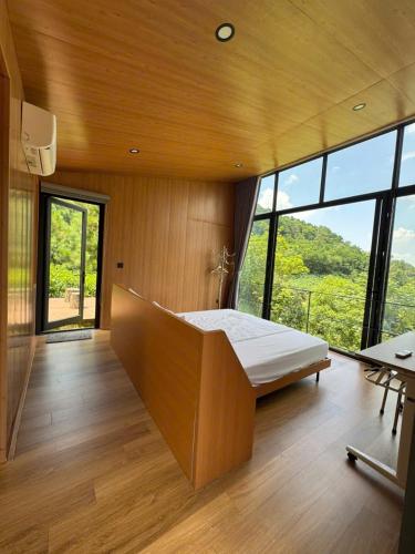 a bedroom with a bed in a room with windows at Pine Hill Villa 3 Vì in Ba Vì