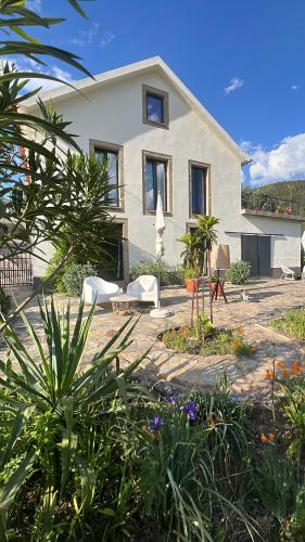 a house with chairs and plants in front of it at Quinta do Brejo in Vila Cova à Coelheira