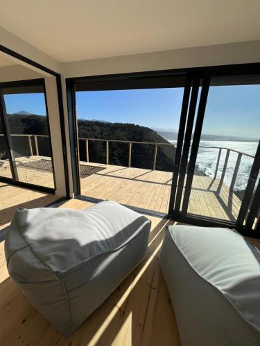a room with a bed and a view of the ocean at Ocean's Edge - Private Nature Reserve in George