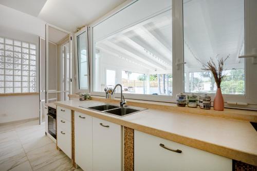 a kitchen with a sink and a large window at GuestHost - Lume di Mare in Faccia di Trippa