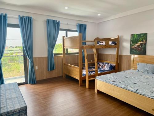 a bedroom with two bunk beds and a window at Villa 1985 in Buon Ma Thuot
