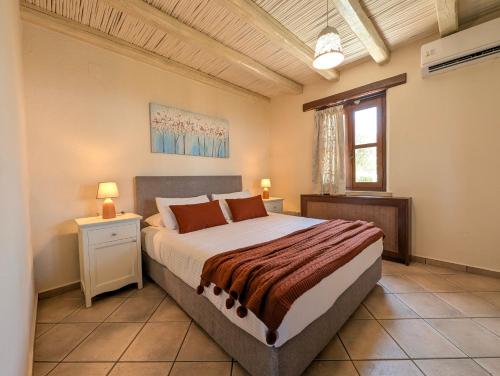 a bedroom with a large bed and a window at Fyllosia Villa Part of Cretan Retreat in Archanes