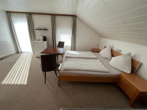 a bedroom with a bed and a desk and a table at Gästehaus Jedinger - Easy Lake Access by Tram in Sankt Georgen im Attergau