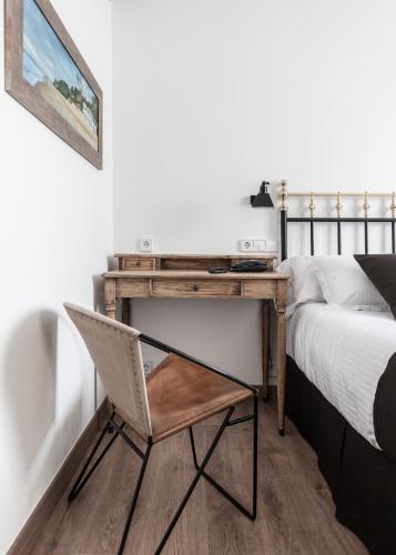 a desk in a bedroom with a bed and a chair at Suite Home Sardinero in Santander