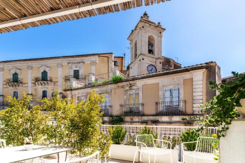 ein Gebäude mit einem Uhrturm und einer Kirche in der Unterkunft Iblaresort Boutique Hotel in Ragusa