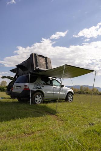 a car with a tent on top of it at car camping rental in Shkodër