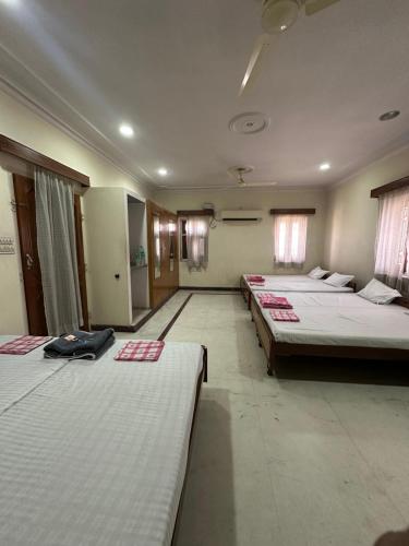 a large room with three beds in it at Ashish Marriage Place in Jaipur