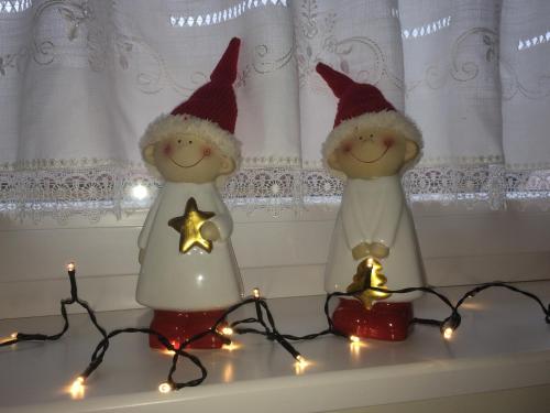 two santa claus dolls sitting on a shelf with christmas lights at Alte Heimat in Schwegenheim