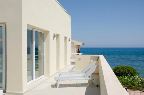 a balcony with two lounge chairs overlooking the ocean at Cicirìa - Private Seafront Suites in Avola