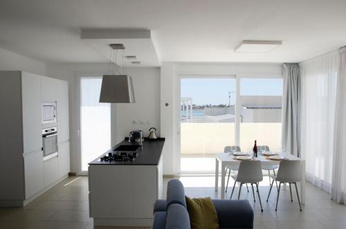 a kitchen and living room with a table and chairs at Cicirìa - Private Seafront Suites in Avola