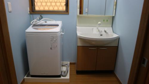 a small bathroom with a sink and a water heater at Sakuraya 亀島店 in Nagoya