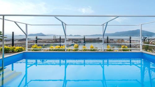 a swimming pool with a view of the water at Yeosu Wayo Ocean View Pension in Yeosu
