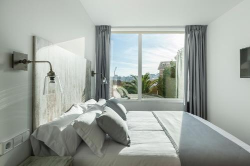 a bedroom with a large bed with a large window at Suite Home Sardinero in Santander