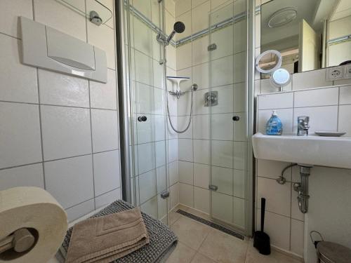 a bathroom with a shower and a sink at Lütt Hüs 1 in Wenningstedt