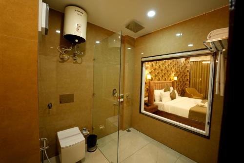 a bathroom with a shower and a toilet and a bed at DN Resort Dharamshala in McLeod Ganj