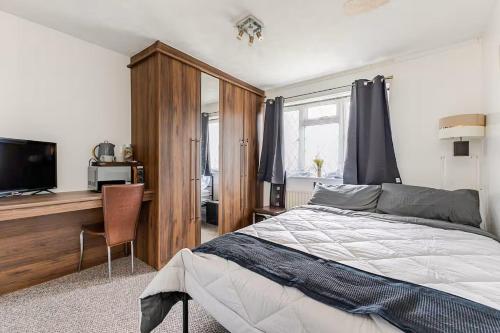 a bedroom with a bed and a desk and a television at Rest & Nest in Chelsfield