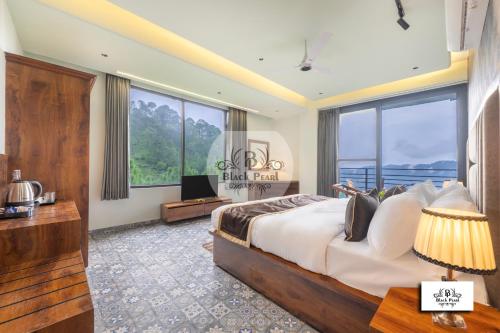 a bedroom with a large bed and a large window at Maverick Heights in Kasauli