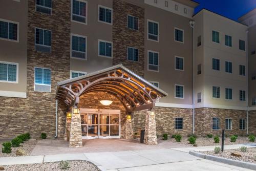an exterior view of a building with an archway at Staybridge Suites - Pecos by IHG in Pecos