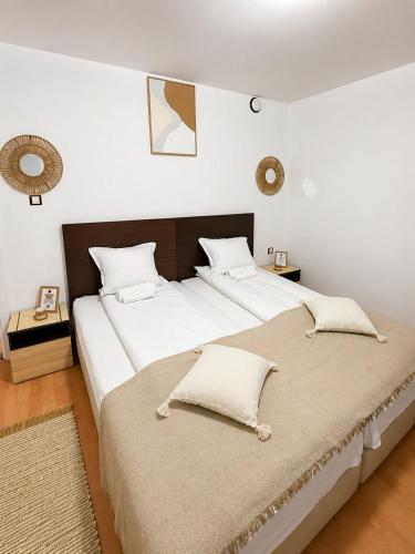 a bedroom with a large bed with two pillows at Къща за гости "Холидей" - Луковит in Lukovit