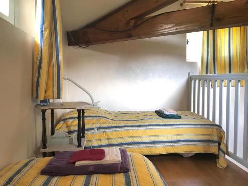 a bedroom with a bed with a striped blanket at Maison dans un parc in Parentignat