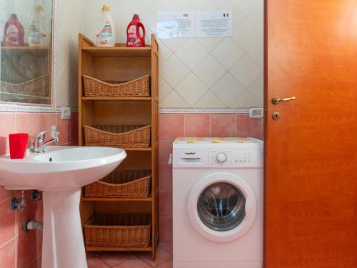a bathroom with a washing machine and a sink at LES PETITES MAISONS Maison rouge in Procida