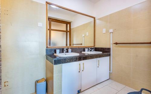 a bathroom with two sinks and a mirror at Bstan Deluxe Beachfront in Diani Beach