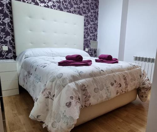 a bedroom with a bed with purple towels on it at Apartamento El Toboso in Alcalá de Henares