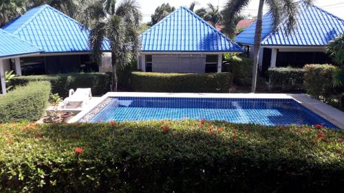 a swimming pool in front of a house with blue roofs at bungalow with swimming pool in Rawai Beach