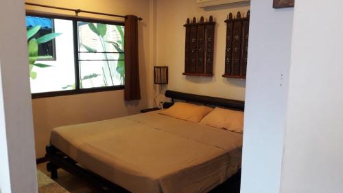 a bedroom with a bed and a window at bungalow with swimming pool in Rawai Beach