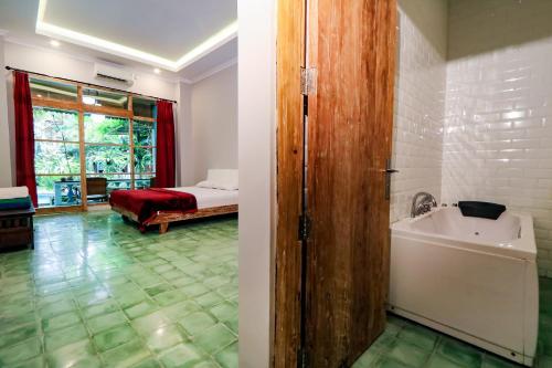 a bathroom with a tub and a sink and a bedroom at Kalipura Villa - Private Pool & Nature Escape in Bantul
