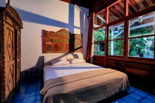 a bedroom with a bed and a window at Kalipura Villa - Private Pool & Nature Escape in Bantul