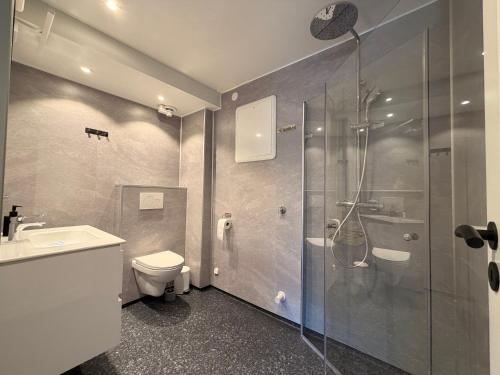 a bathroom with a shower and a toilet and a sink at Historic Strandgata 36 in Tromsø