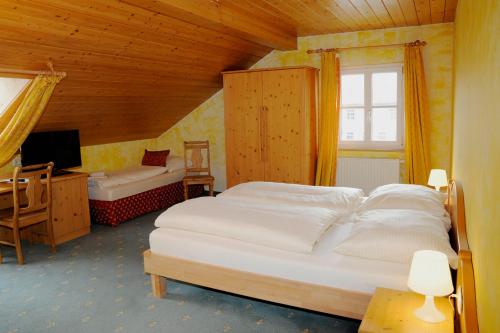 1 dormitorio con 2 camas, escritorio y TV en Gasthaus Marienhof, en Kirchdorf am Inn