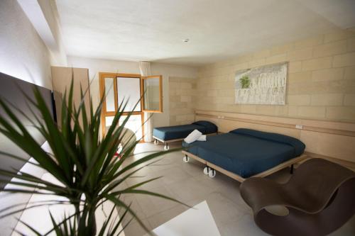 a room with two beds and a plant in it at Cave Bianche Hotel in Favignana