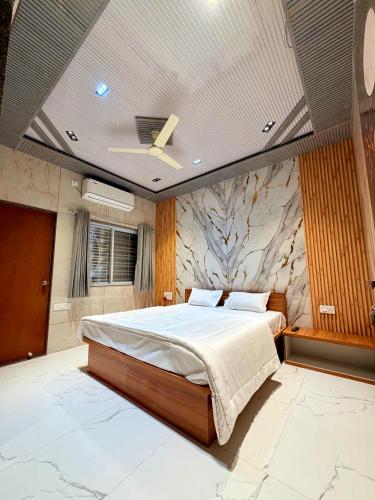 a bedroom with a large bed and a stone wall at Saiprasad suite & stay in Ellora